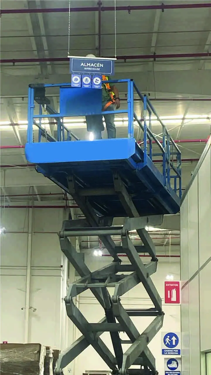 Señalización de almacén instalada con plataforma de tijera